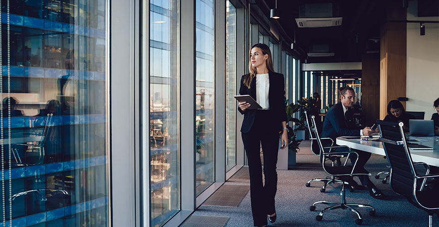 Woman walking in office with ipad